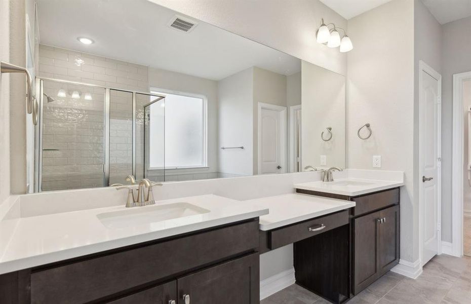 Elegant owner's suite with dual vanity *real home pictured