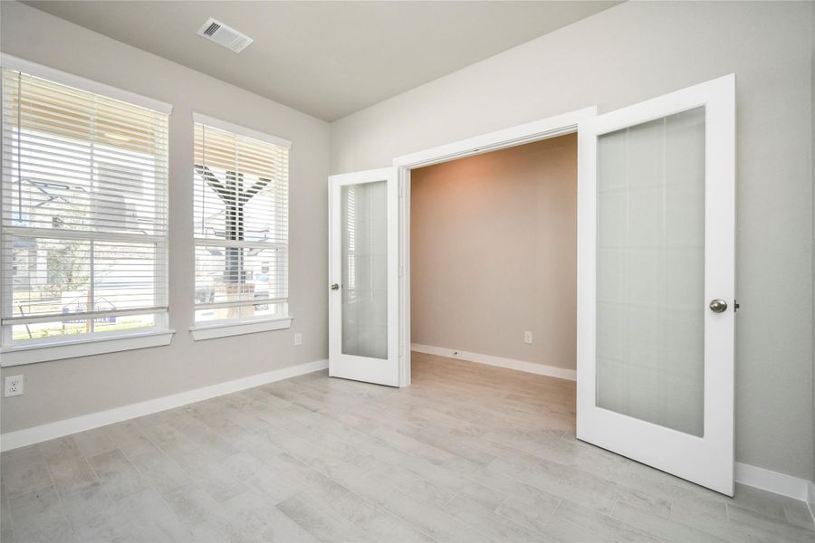 At the forefront, a refined home office beckons productivity and focus. Luxurious details like tile flooring, custom paint, expansive windows with privacy blinds, and French doors create an inspiring workspace. Sample photo of completed home with similar floor plan. Actual colors and selections may vary. At the forefront, a refined home office beckons productivity and focus. Luxurious details like tile flooring, custom paint, expansive windows with privacy blinds, and French doors create an inspiring workspace. Sample photo of completed home with similar floor plan. Actual colors and selections may vary.