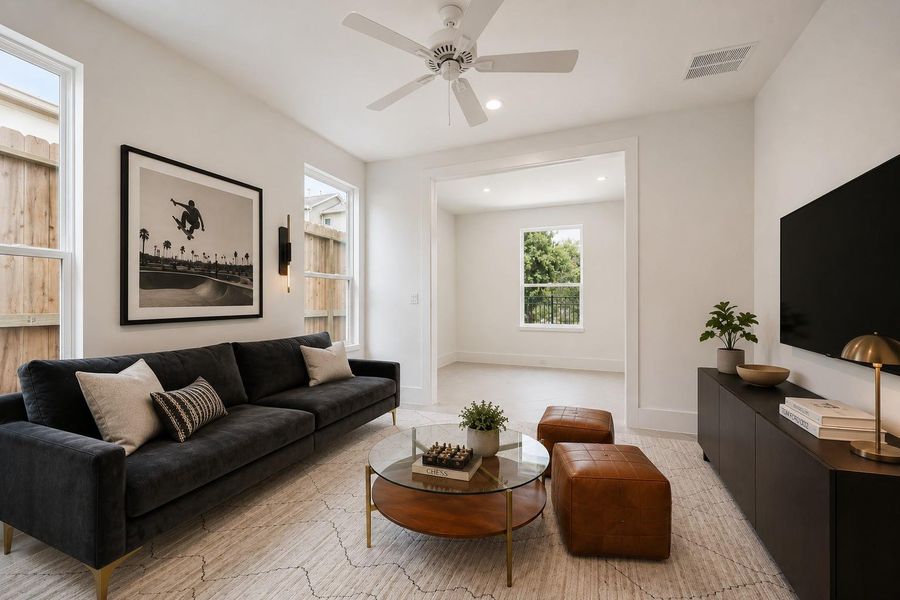 A generously sized third bedroom. Currently staged as a game room/second living space — the perfect flexible secondary bed. A digitally enhanced image.