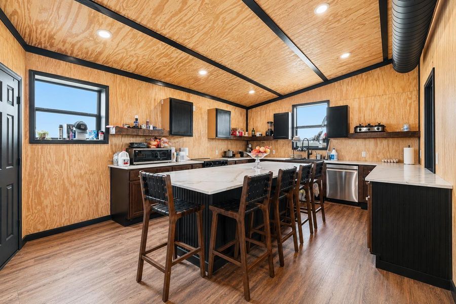 A contemporary kitchen offers ample counter space, a central island with seating, and integrated appliances.