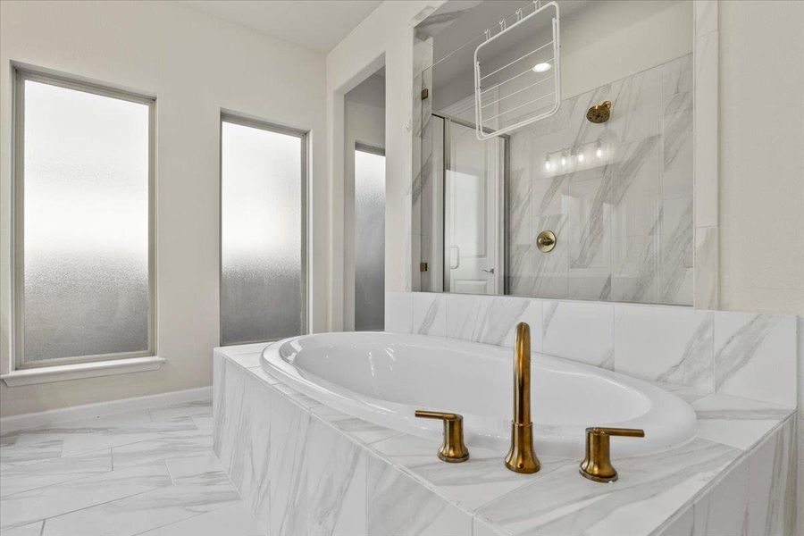 Bathroom with a marble finish shower, a bath, and marble finish floors Bathroom with a marble finish shower, a bath, and marble finish floors