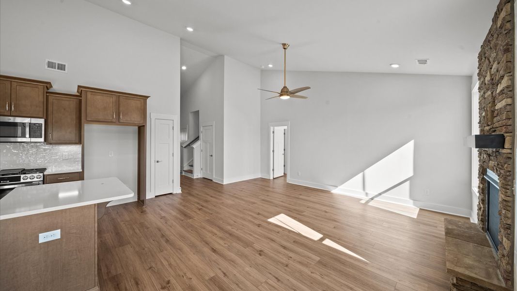 Highly skilled craftsmanship and modern elegance meet in this family room with soaring ceilings and stone fireplace