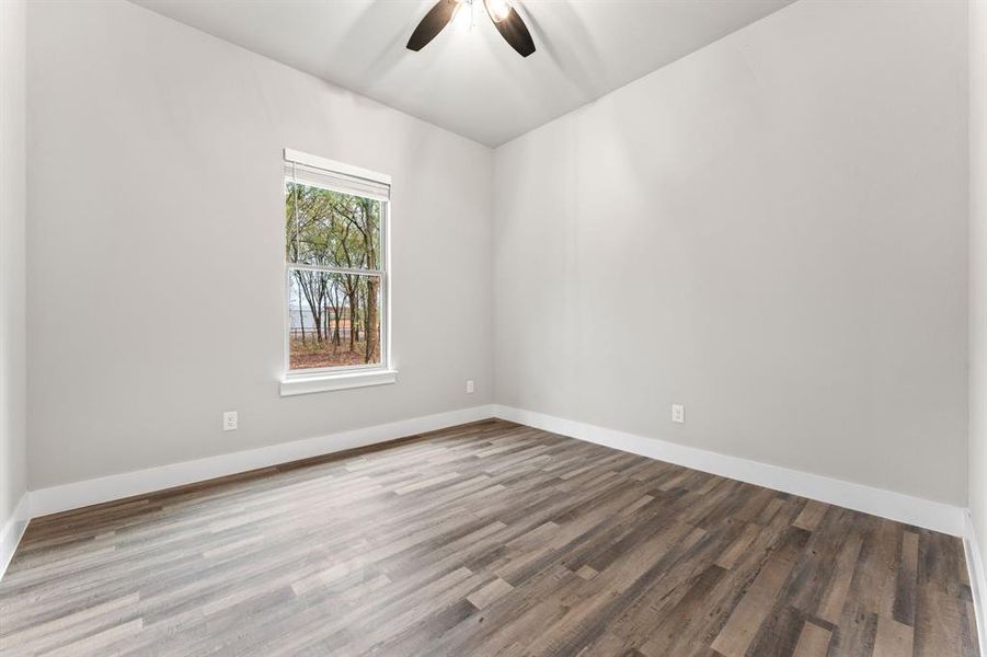 Empty room featuring ceiling fan and wood-type flooring