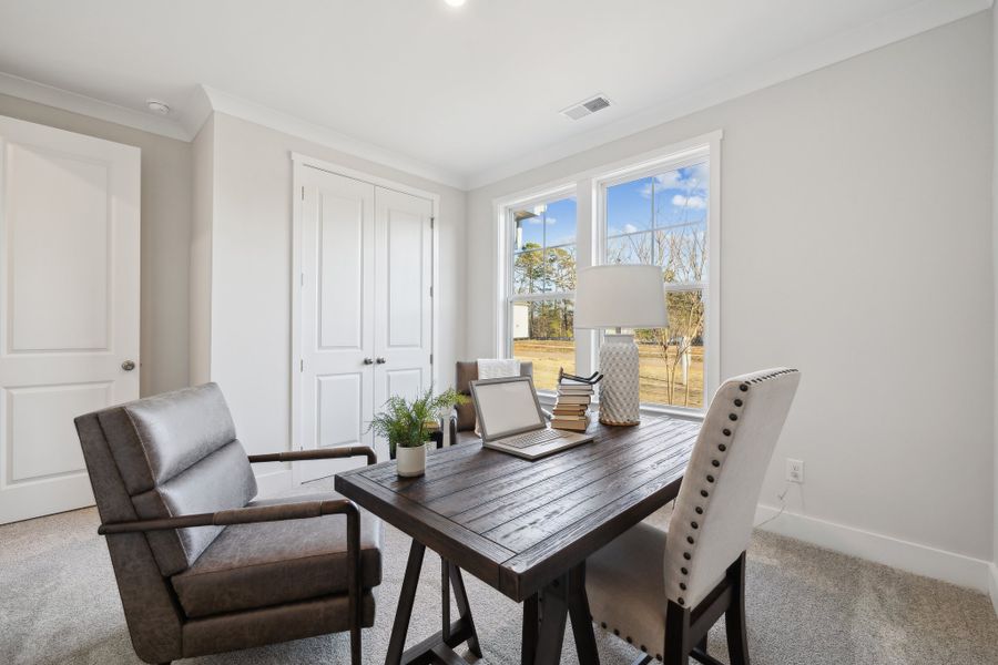 A living room with a table and chairs.