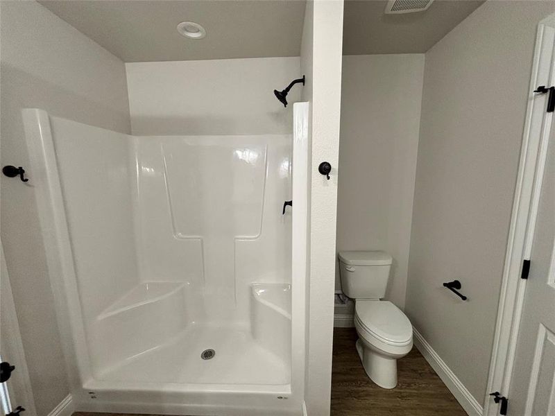 Bathroom with a shower stall and dark wood finished floors