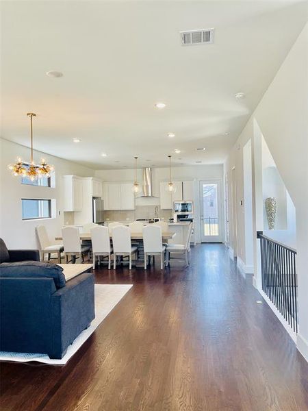 Living area with dark wood finished floors, recessed lighting, and a chandelier Living area with dark wood finished floors, recessed lighting, and a chandelier