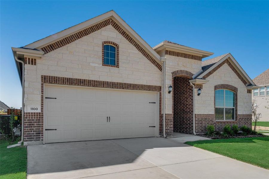 View of front of home featuring a front yard and a garage