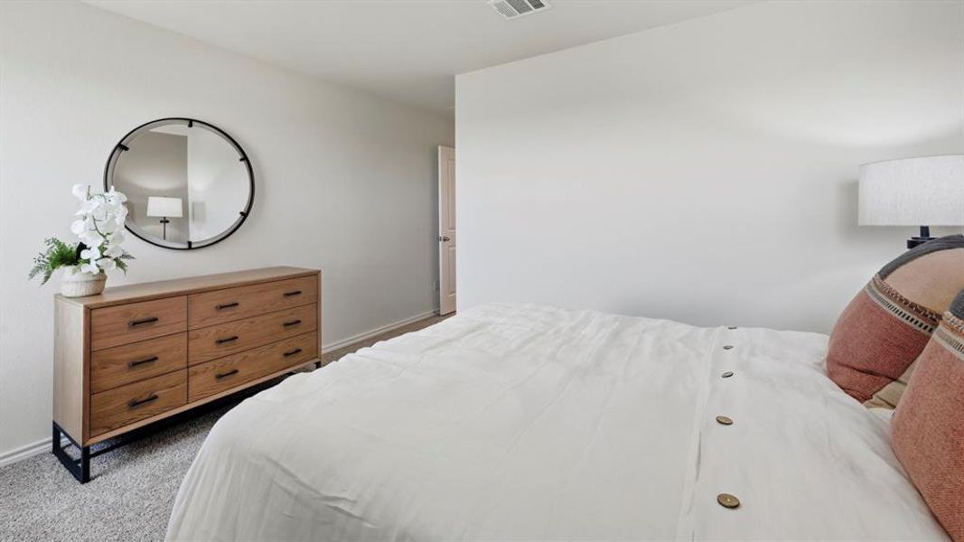 Bedroom with light colored carpet and baseboards