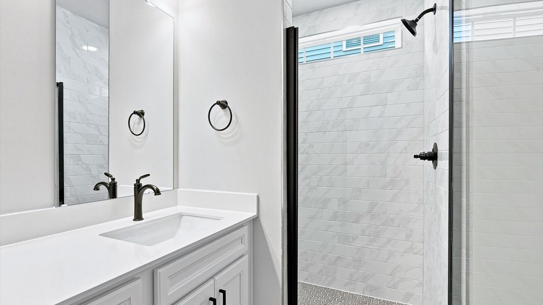 Accomplished design shines in this primary bath with dual vanity and a sleek tiled walk-in shower Accomplished design shines in this primary bath with dual vanity and a sleek tiled walk-in shower