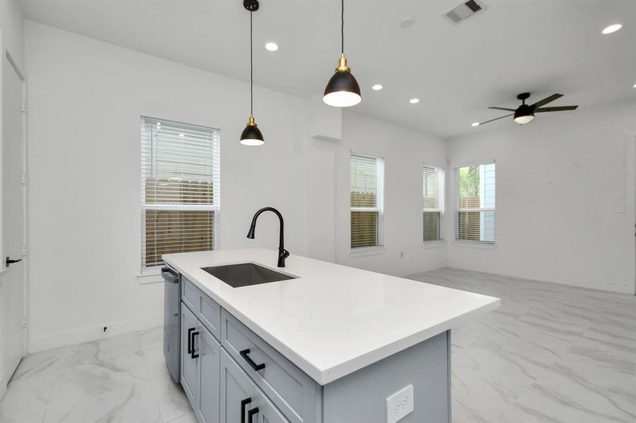 Another view from this well-appointed kitchen into the open living area, offering ample room for comfortably entertaining or relaxing at home with the family.