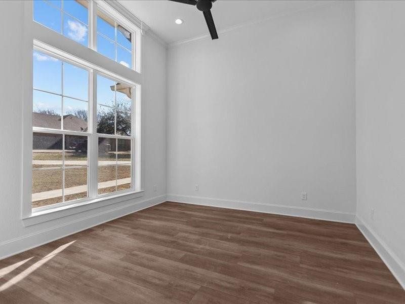 Spare room with dark wood-type flooring, crown molding, ceiling fan, and recessed lighting