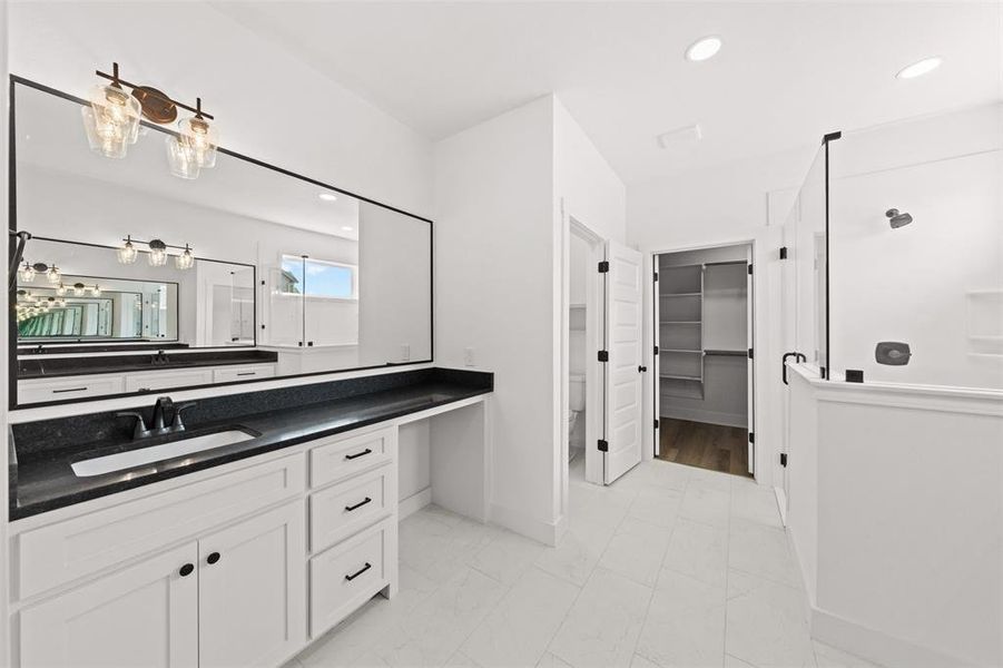 Full bath featuring a walk in closet, vanity, walk in shower, and recessed lighting