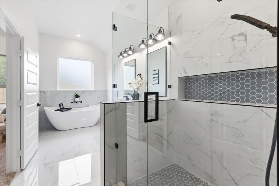 Full bathroom featuring tile walls, a marble finish shower, healthy amount of natural light, light marble finish floors, and vanity