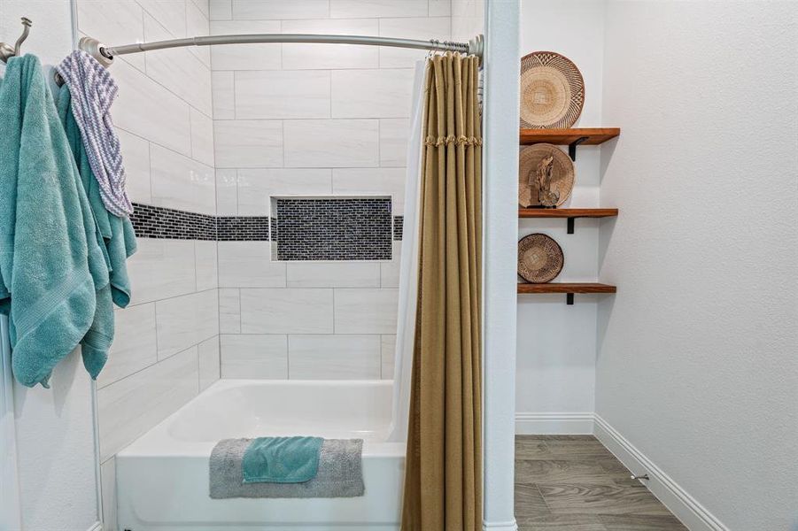 Bathroom featuring shower / bath combo with shower curtain and wood finished floors