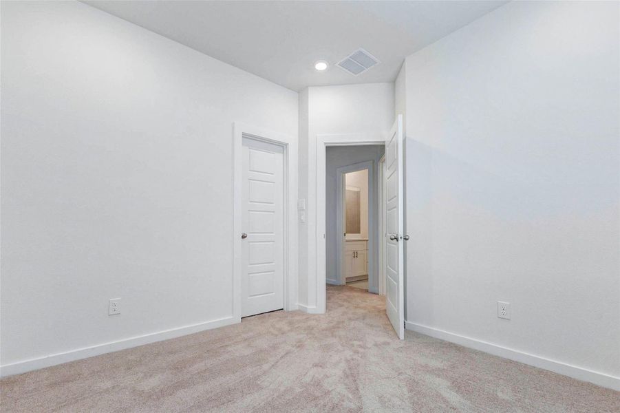 Another bedroom view highlights the tall ceiling, soft carpet, clean white walls, and convenient door access to nearby spaces. The room offers a flexible layout with plenty of wall space, making it easy to arrange as a bedroom, office, playroom, or additional living space. Another bedroom view highlights the tall ceiling, soft carpet, clean white walls, and convenient door access to nearby spaces. The room offers a flexible layout with plenty of wall space, making it easy to arrange as a bedroom, office, playroom, or additional living space.