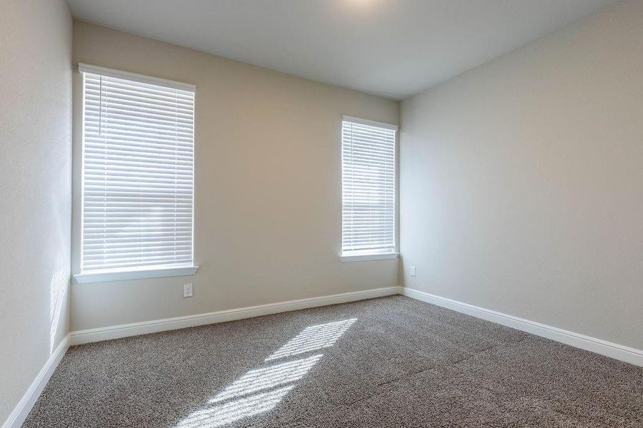 Carpeted spare room featuring baseboards Carpeted spare room featuring baseboards