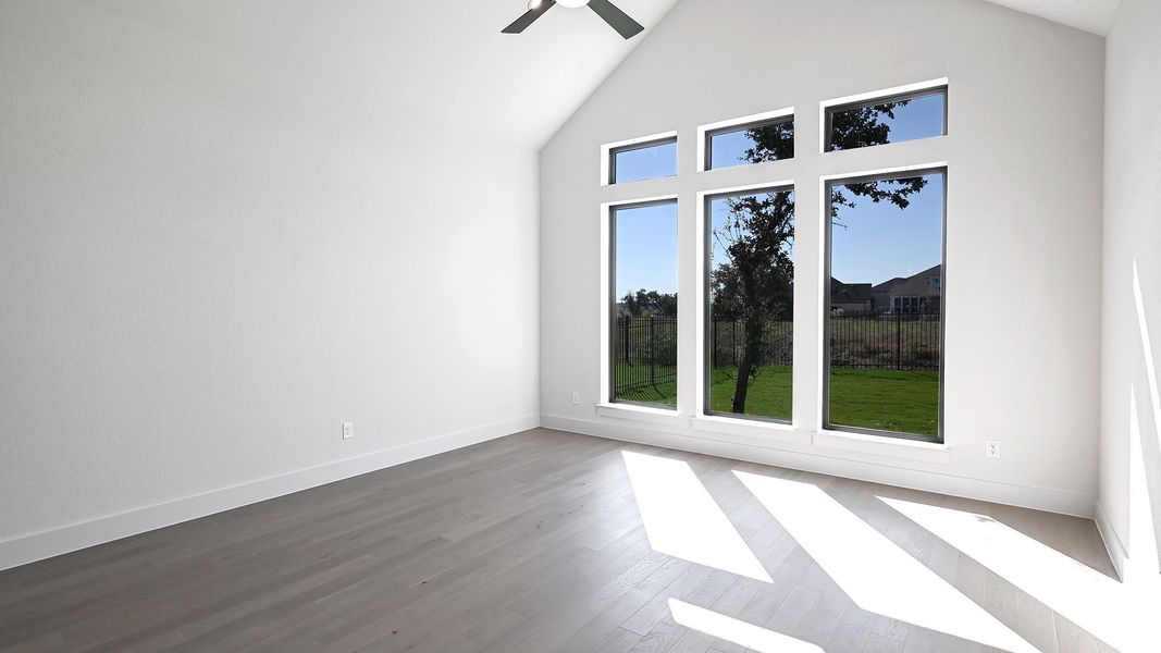 Unfurnished room with high vaulted ceiling, ceiling fan, and dark wood-type flooring Unfurnished room with high vaulted ceiling, ceiling fan, and dark wood-type flooring