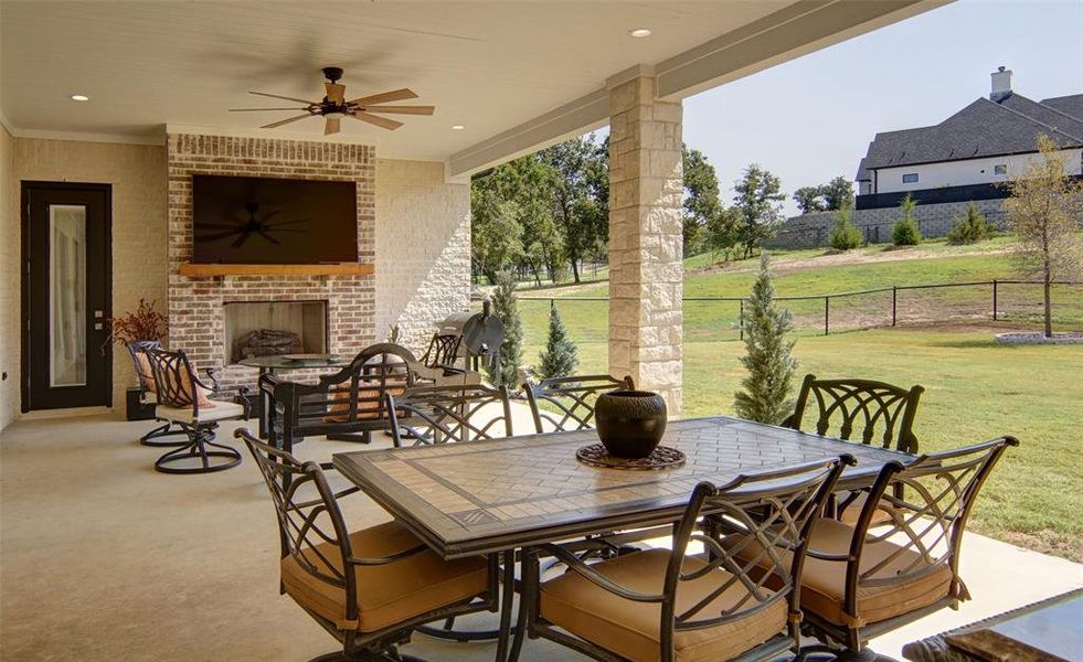 View of patio / terrace with ceiling fan and an outdoor brick fireplace