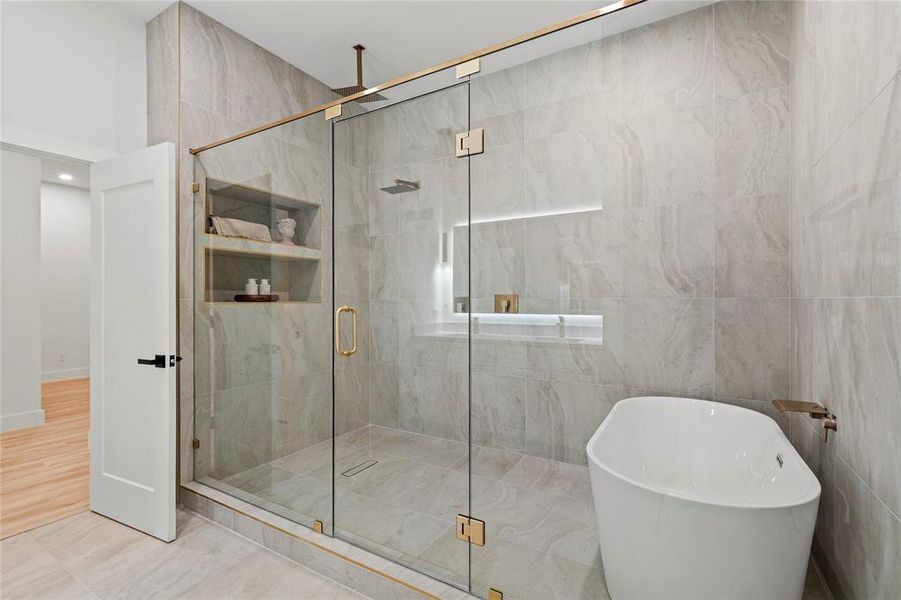 Bathroom featuring a freestanding bath, a stall shower, and tile walls Bathroom featuring a freestanding bath, a stall shower, and tile walls