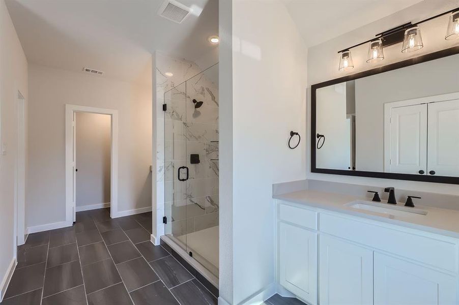 Bathroom featuring vanity and an enclosed shower