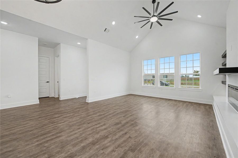 Spacious open floor plan with high ceilings, designer lighting, and seamless flow from living to kitchen.