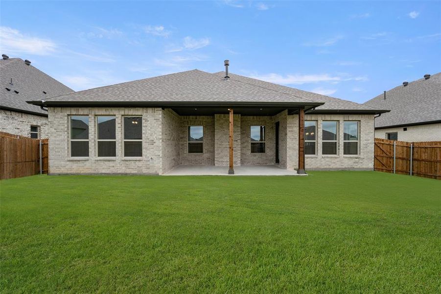 Rear view of property with a patio area, a fenced backyard, brick siding, and roof with shingles Rear view of property with a patio area, a fenced backyard, brick siding, and roof with shingles