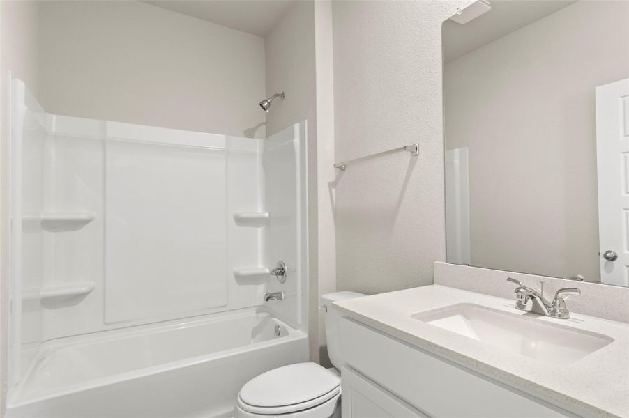 Full bath featuring vanity, tub / shower combination, and a textured wall