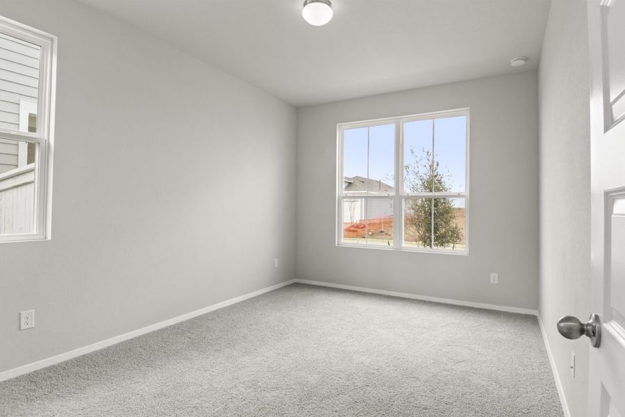 Image of bedroom with light grey walls and carpet with a window