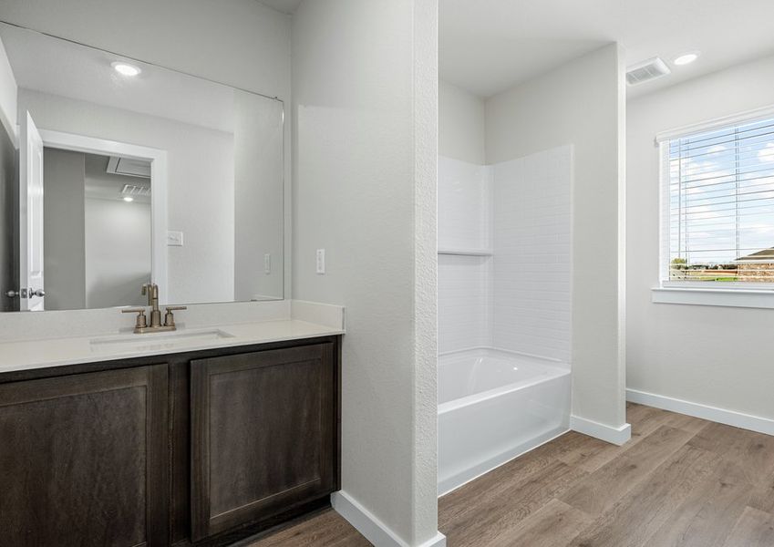 The secondary bathroom has a vanity space and a shower-tub combo.