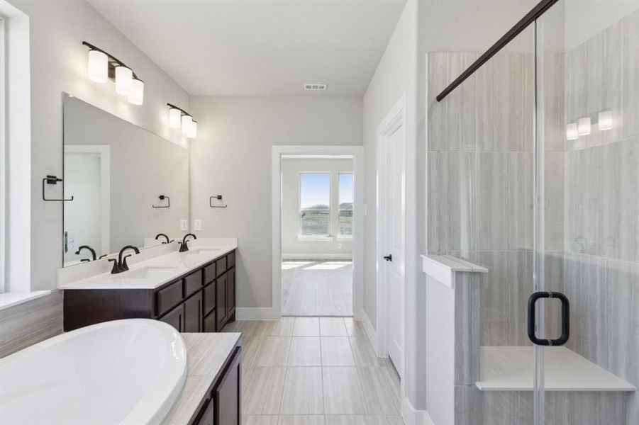 Full bathroom featuring double vanity, visible vents, a shower stall, and a sink