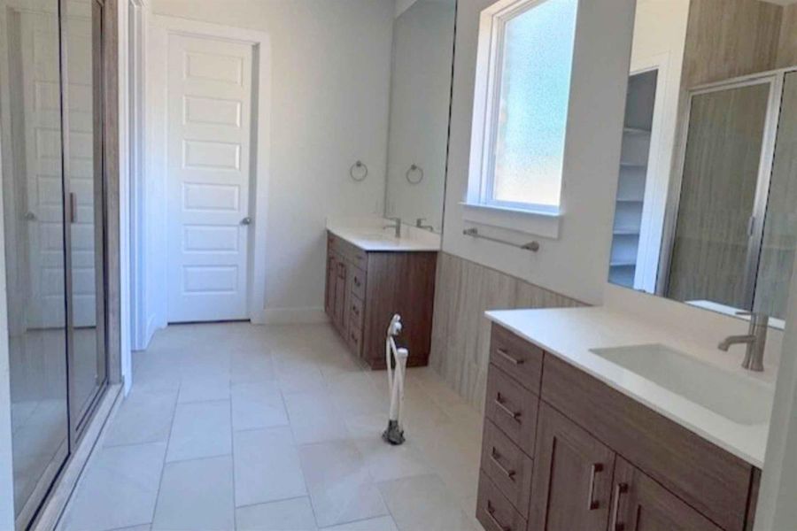Full bathroom with a stall shower and two vanities