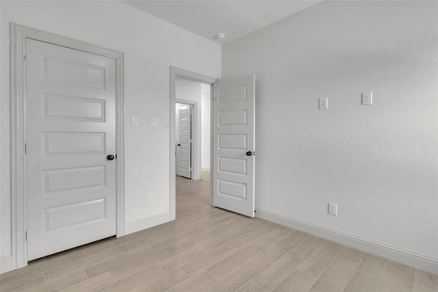 Unfurnished bedroom featuring light wood-style floors and baseboards Unfurnished bedroom featuring light wood-style floors and baseboards