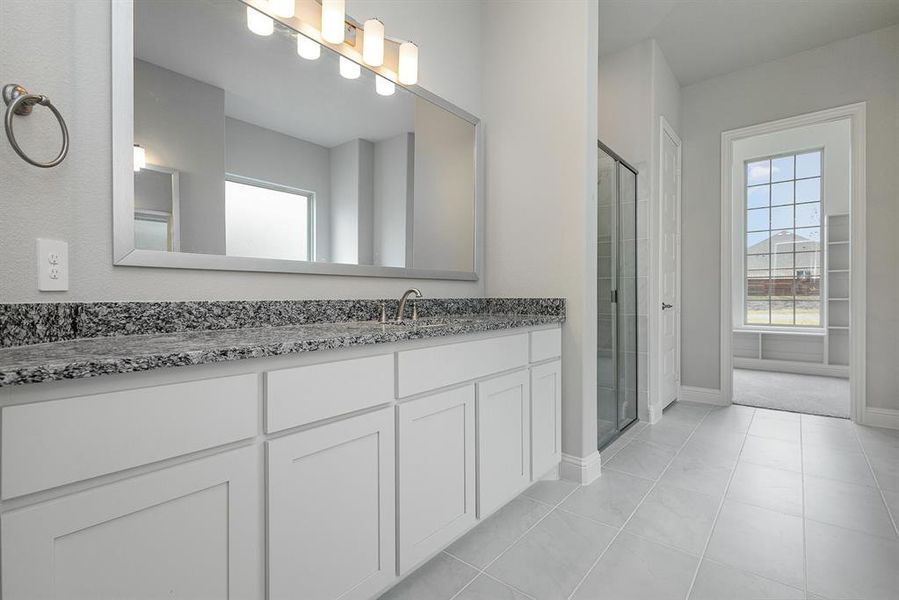 Bathroom with tile patterned floors, vanity, and an enclosed shower