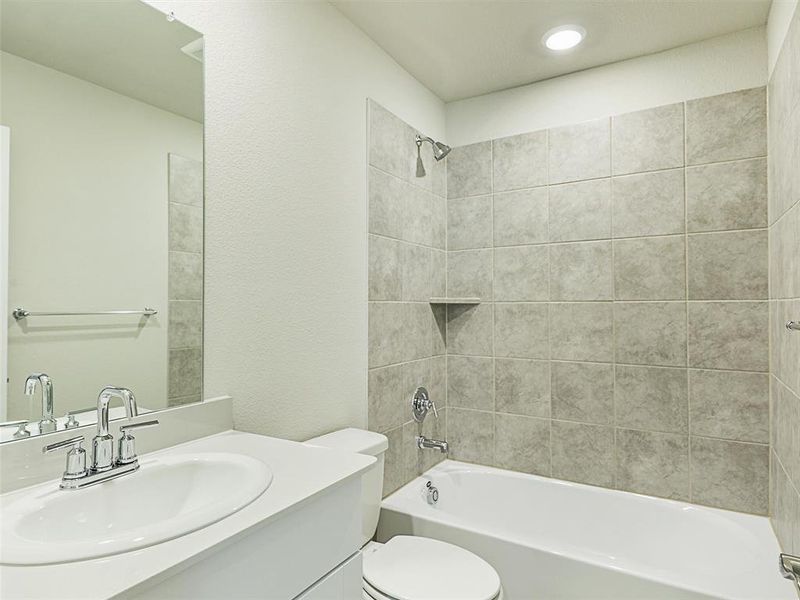 Full bathroom featuring vanity, toilet, and tiled shower / bath