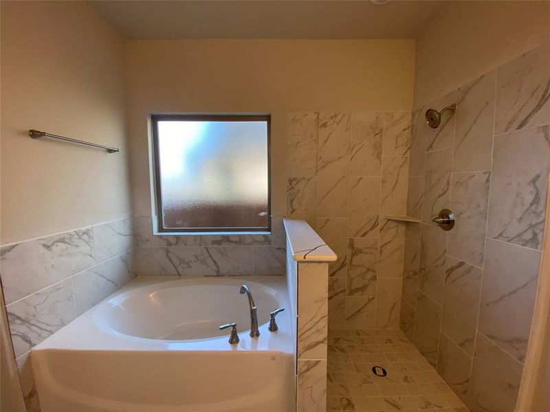 Master bath has garden tub, walk-in shower with dropped tile pan, enclosed with frameless glass (not installed yet.)