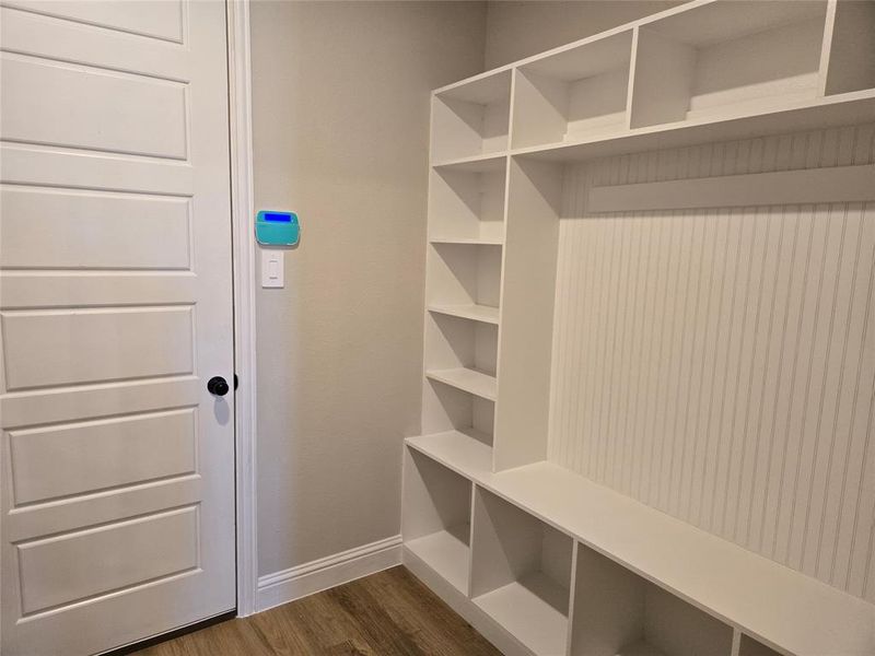 Mudroom with dark wood-style floors and baseboards