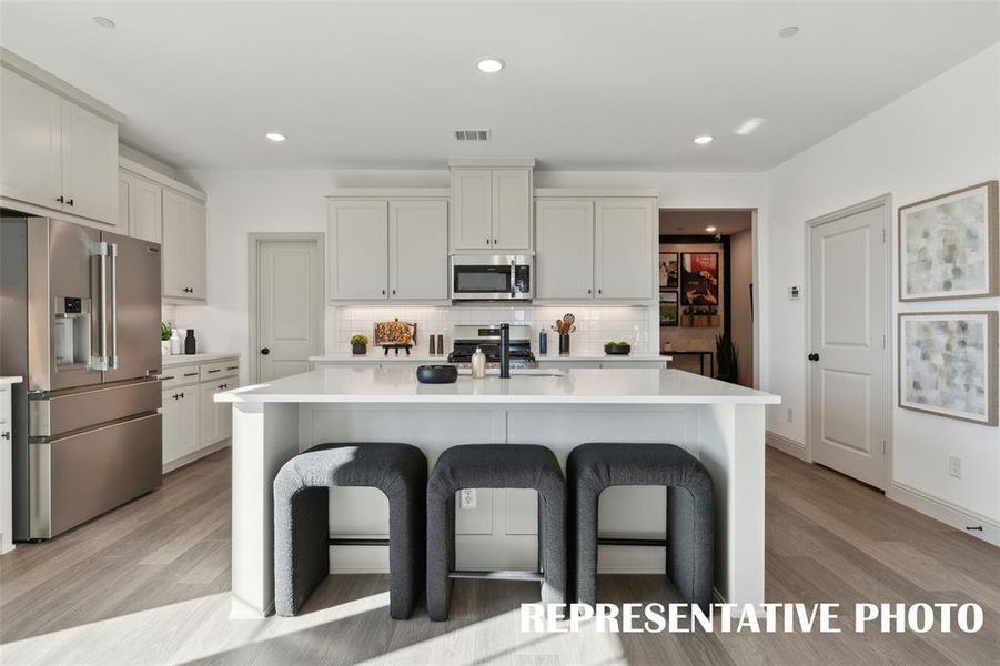 The large kitchen island creates the perfect gathering place for family and friends!  REPRESENTATIVE PHOTO