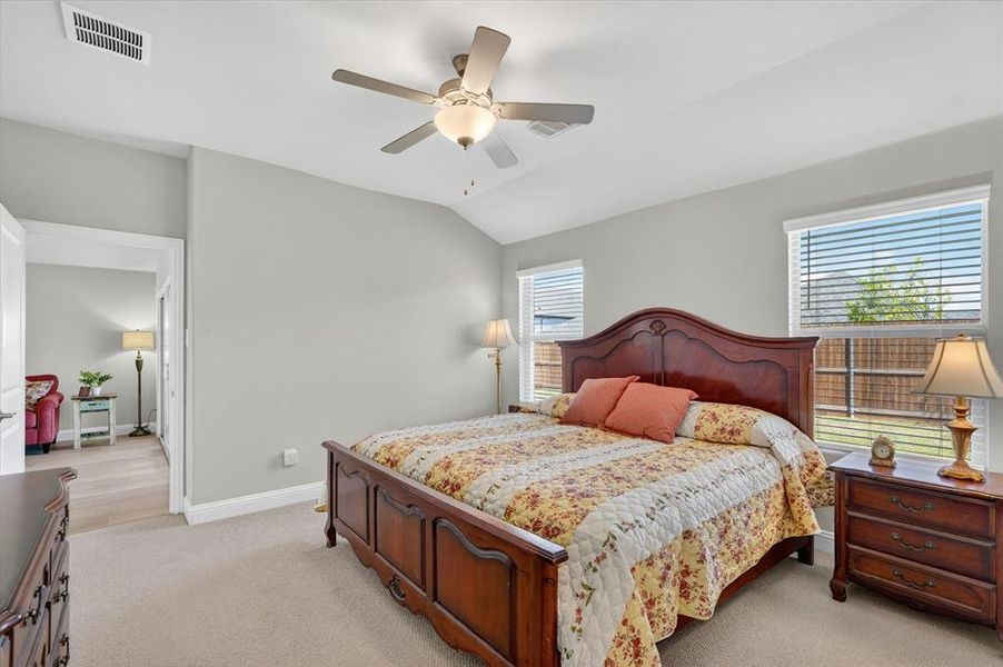 Carpeted room with vaulted ceiling and a ceiling fan with integrated lighting Carpeted room with vaulted ceiling and a ceiling fan with integrated lighting