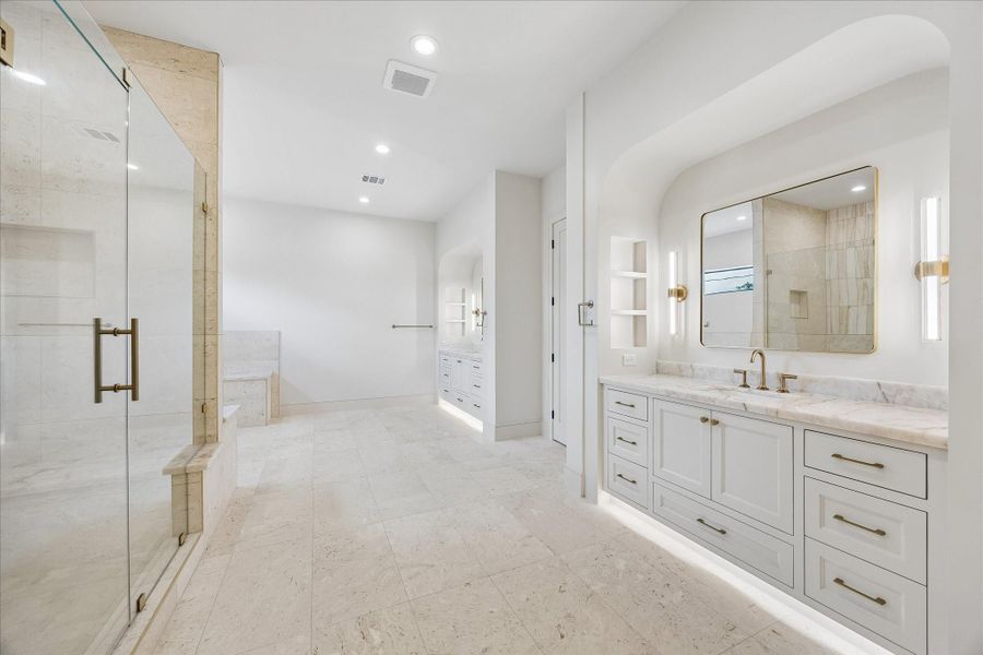 Spa inspired luxury begins with an expansive walk in shower, and dual vanities finished with marble countertops and designer lighting. Thoughtful details throughout create a serene retreat designed for everyday comfort.