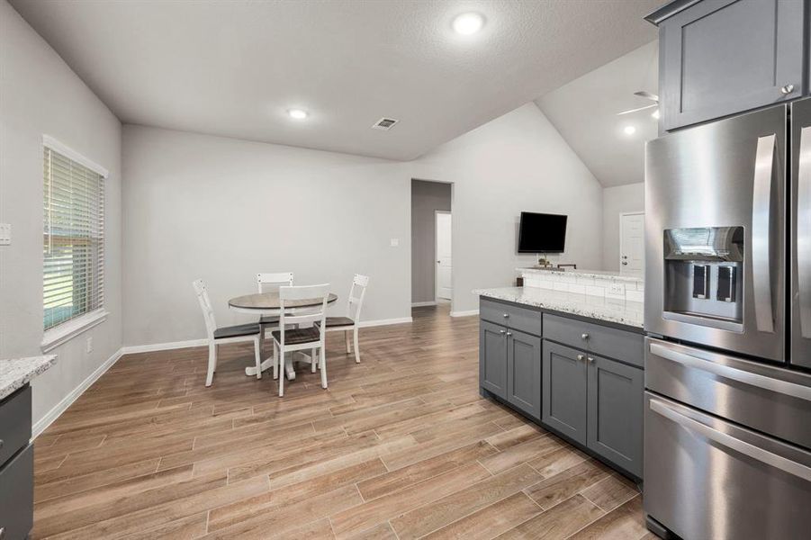 The breakfast bar and breakfast area perfect for those meals on the go. Note the high ceilings and gorgeous   wood look tile floors.