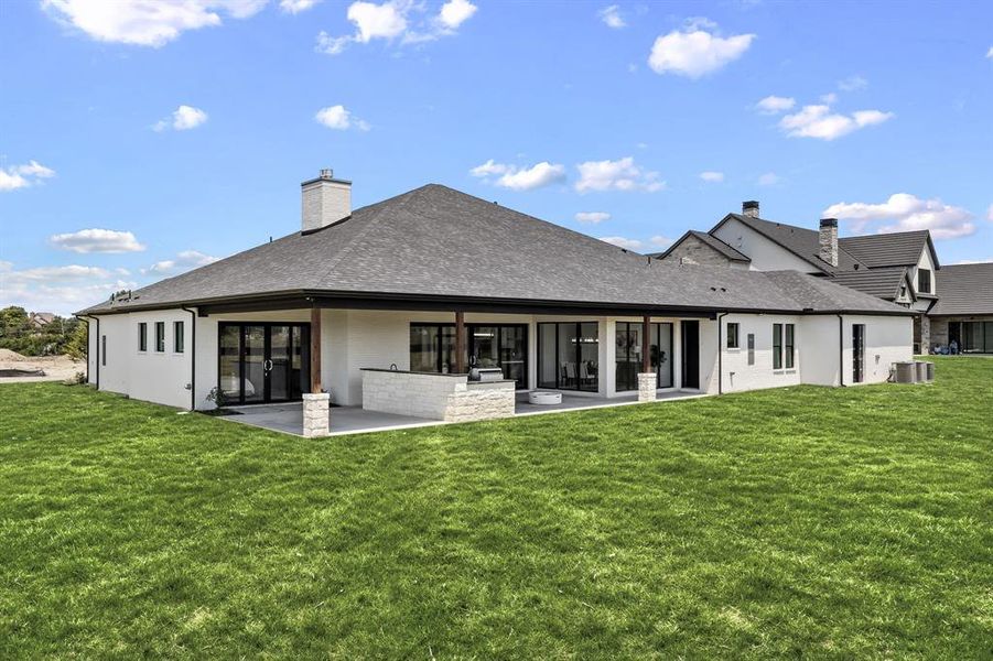 Rear view of property with a chimney, a yard, a patio, and area for grilling