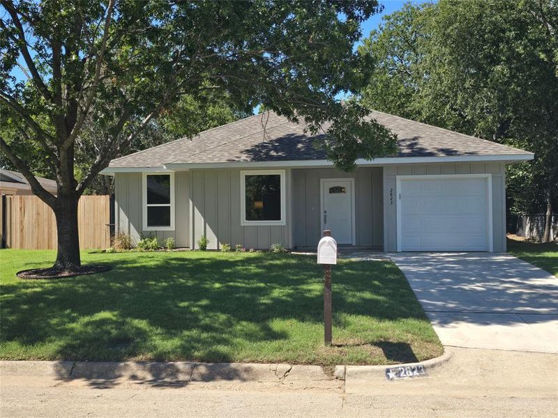 Single story home featuring a front lawn and a garage