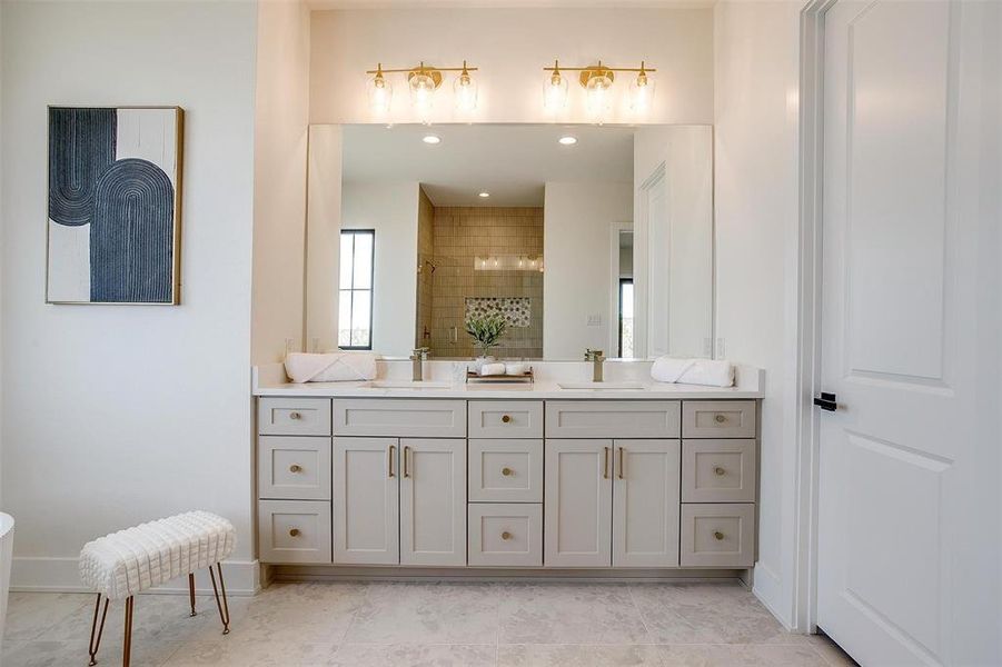 Bathroom featuring a shower stall, double vanity, baseboards, and a sink