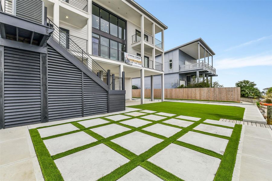 Spend more time enjoying the bay and less time maintaining the lawn. Artificial turf and geometric pavers keep the outdoor setting clean, green, and ready for year round use. The space can easily support dining, lounging, or entertaining zones. Spend more time enjoying the bay and less time maintaining the lawn. Artificial turf and geometric pavers keep the outdoor setting clean, green, and ready for year round use. The space can easily support dining, lounging, or entertaining zones.