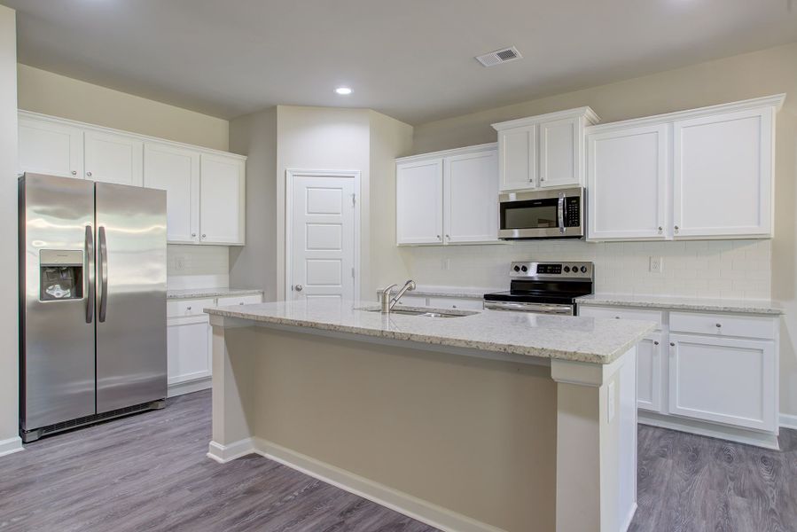 Expansive kitchen with large center island and corner pantry