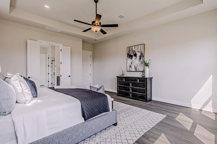 Primary bedroom with a tray ceiling and private access to the en-suite bath