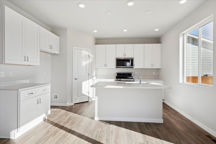 A kitchen with white cabinets.