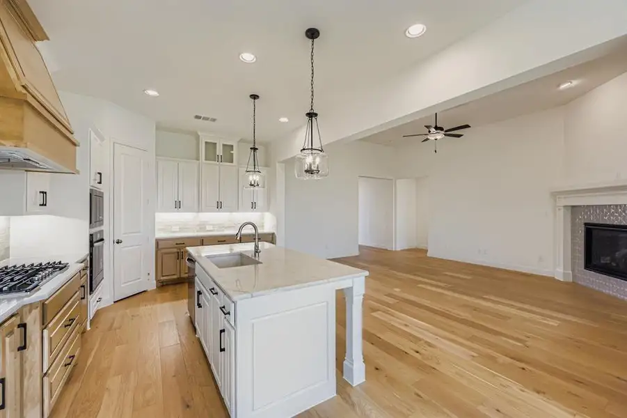 Kitchen with white cabinets, open floor plan, tasteful backsplash, recessed lighting, and light wood-style floors