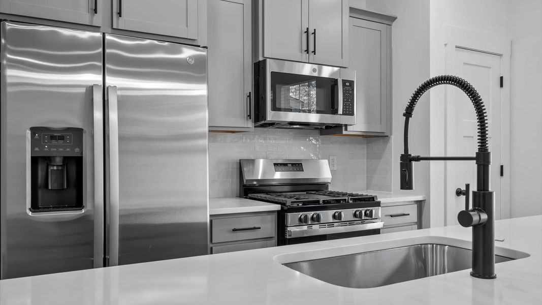 Exclusive DRB Homes kitchen with a 9-foot island, elevated finishes, and pendant lighting in a prime location