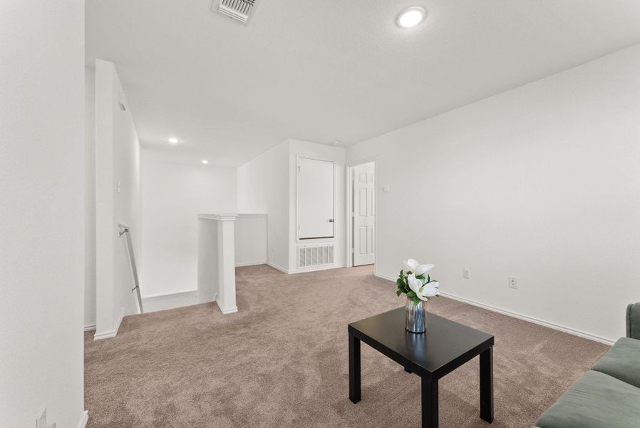 Living room with baseboards, visible vents, and carpet flooring